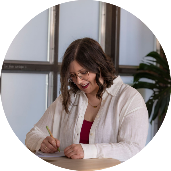 Jenny Schmitz steht an einem Tisch und schreibt etwas in einen Notizblock